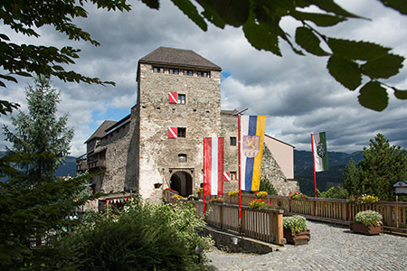 Aussenansicht der Burg Oberkapfenberg mit Turm, Brücke und Fahnen